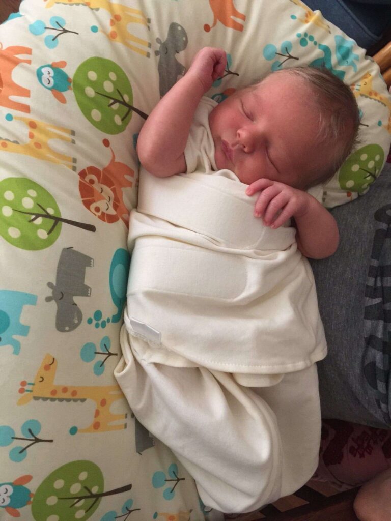 Baby may look cozy, but is not in a safe sleep position!