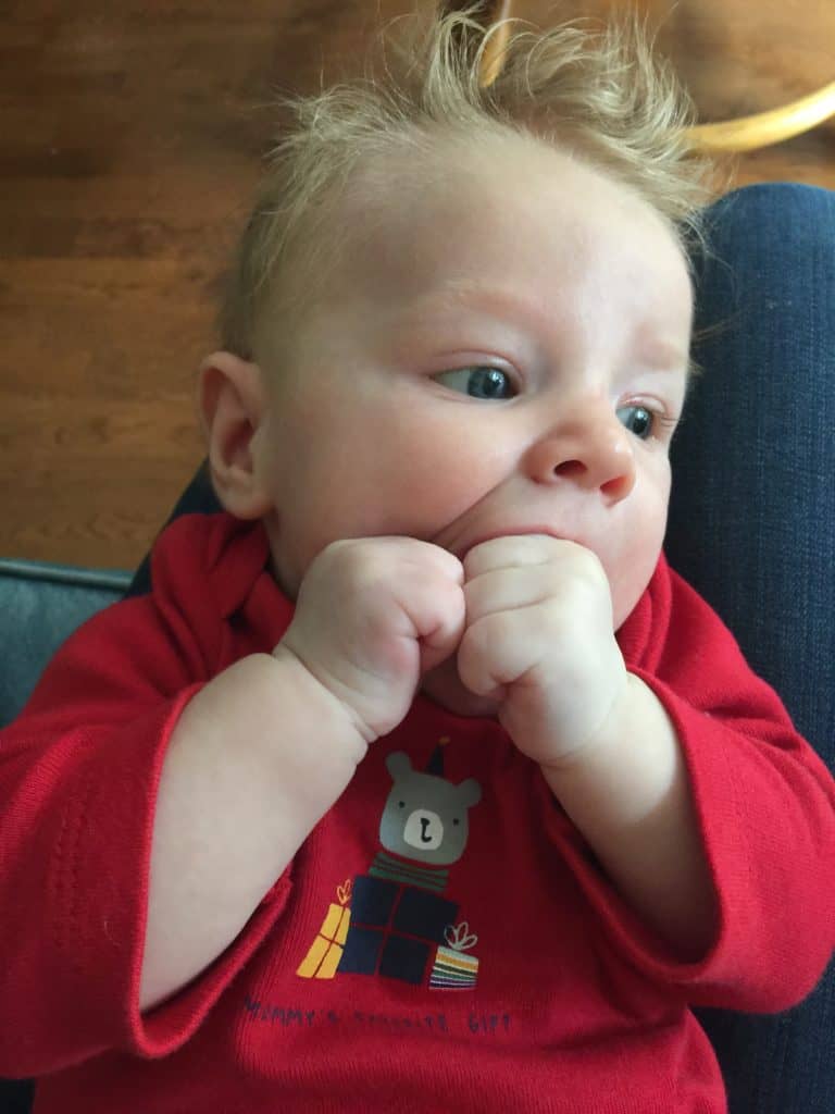Baby chewing on hands. Exploration, not hunger, in 2-month old baby.