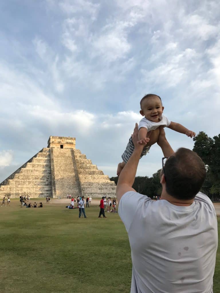 Baby being lifted by a parent in front of Machu Picchu