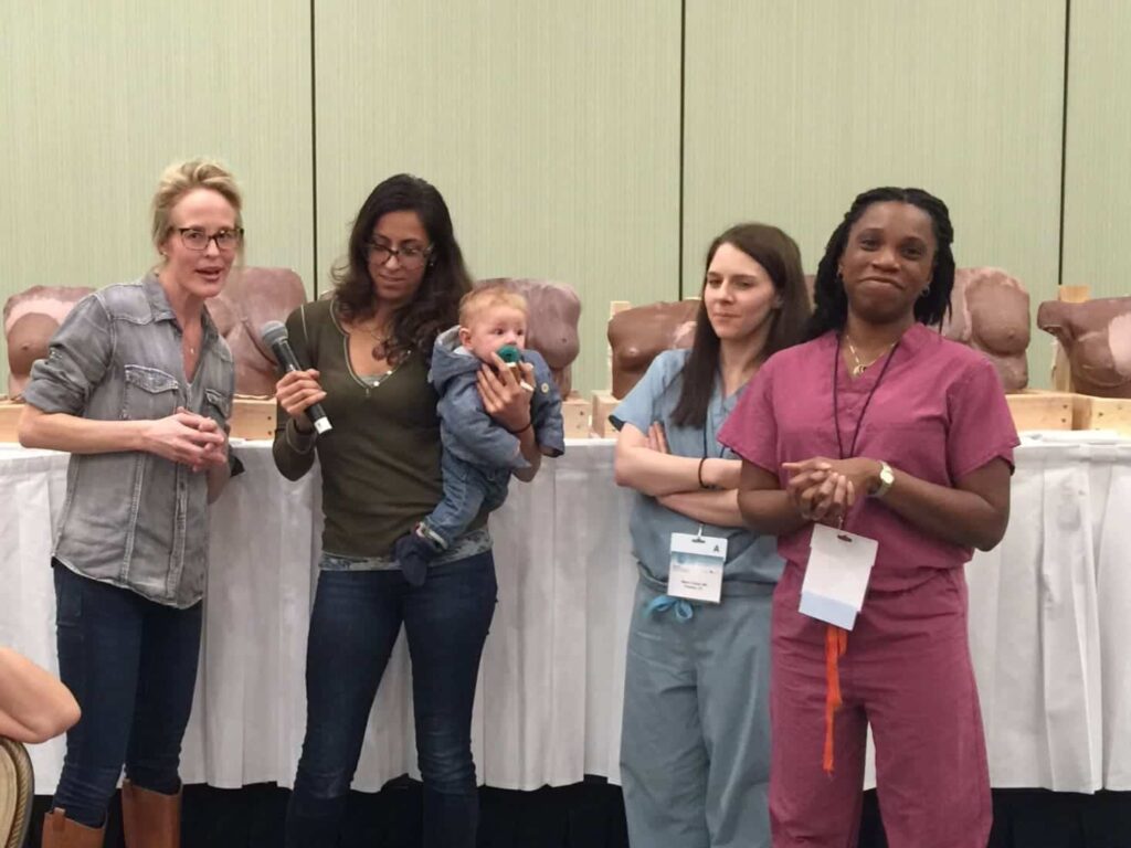 Dr. Mitchell's young son with a group of women surgeons who love to hold him