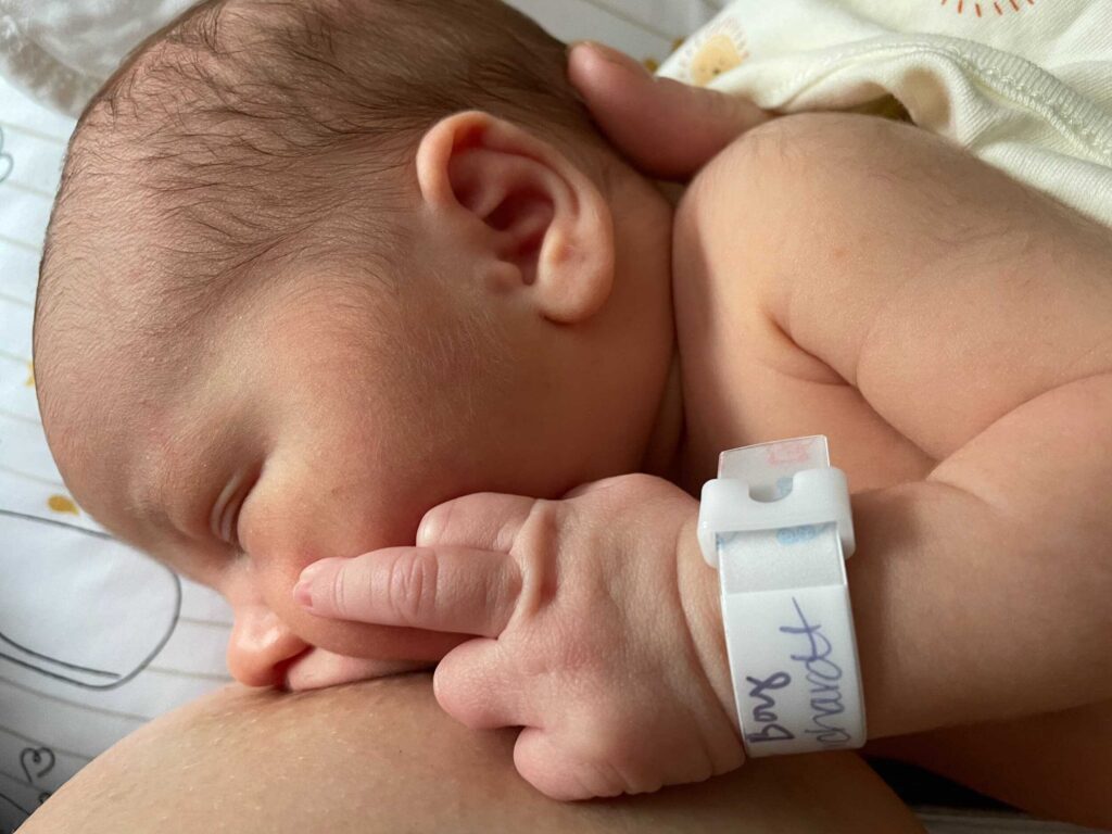 Baby feeding with hand on it's cheek