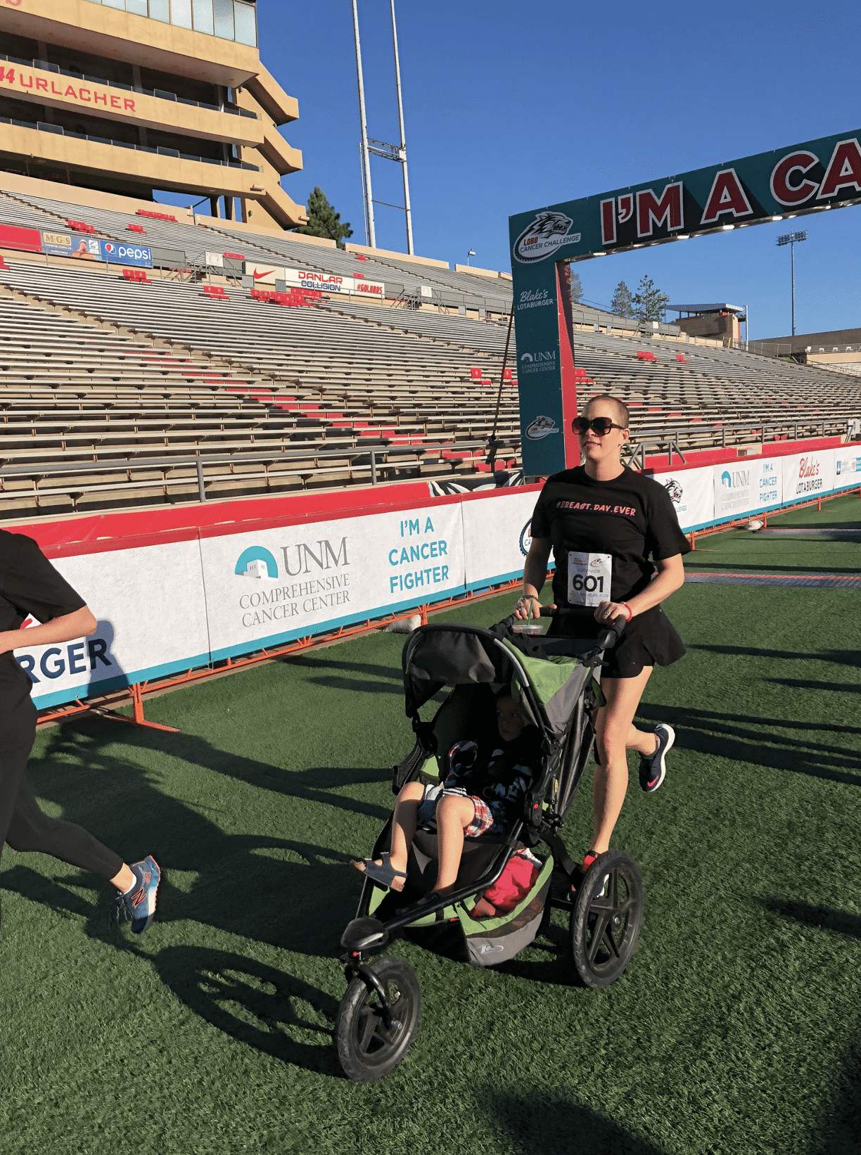 Mom crossing finish line with toddler in stroller