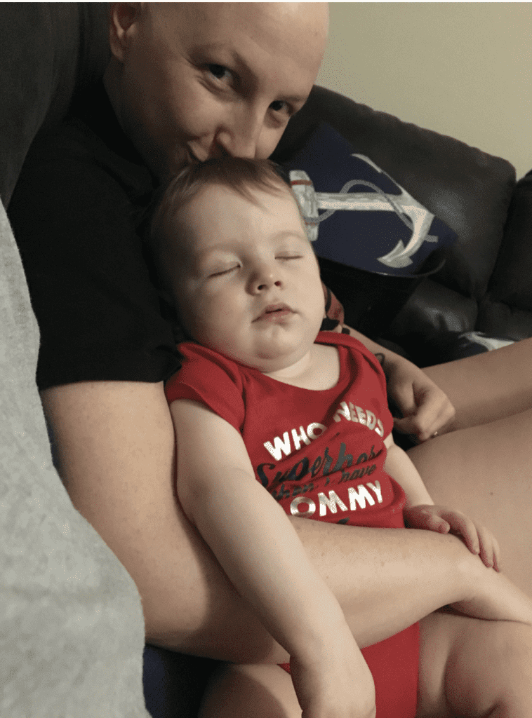 Sleeping baby snuggled up with parent