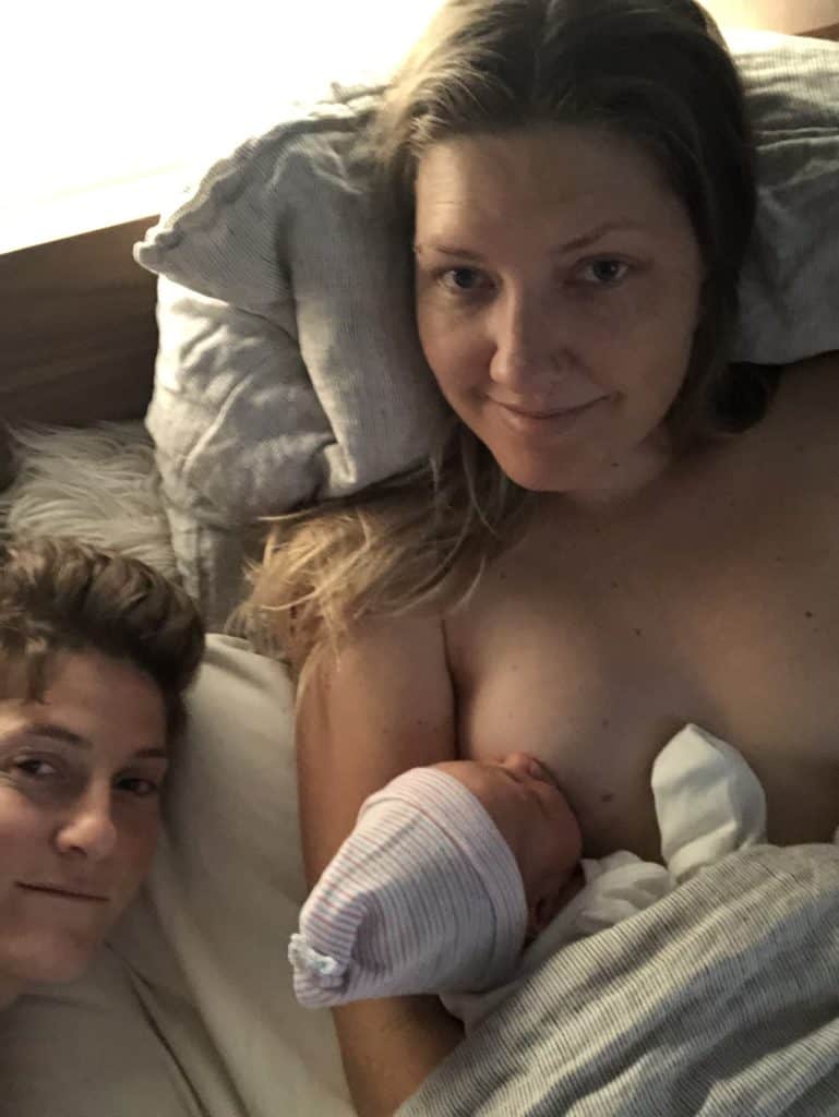 Couple in bed while one breastfeeds the baby