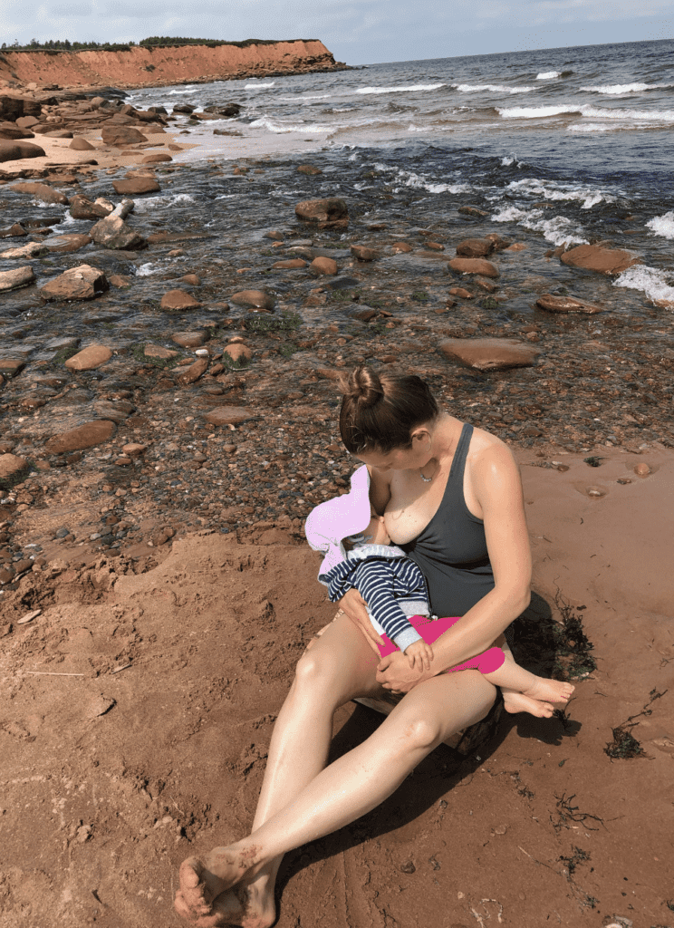 Mom breastfeeding her toddler at the beach